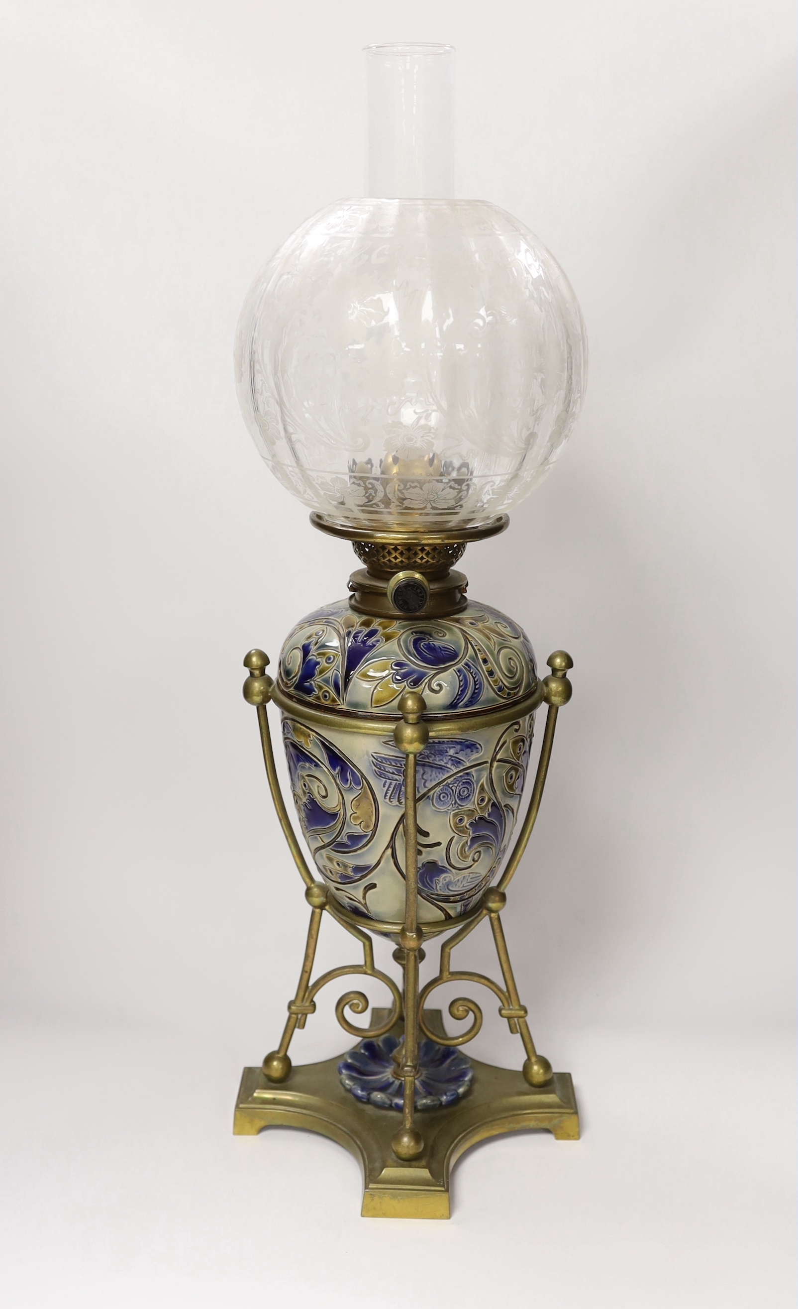 Mark V Marshall for Doulton Lambeth stoneware oil lamp on brass stand with etched glass shade, incised marks to the base of the reservoir, dated 1882, 64cm high overall